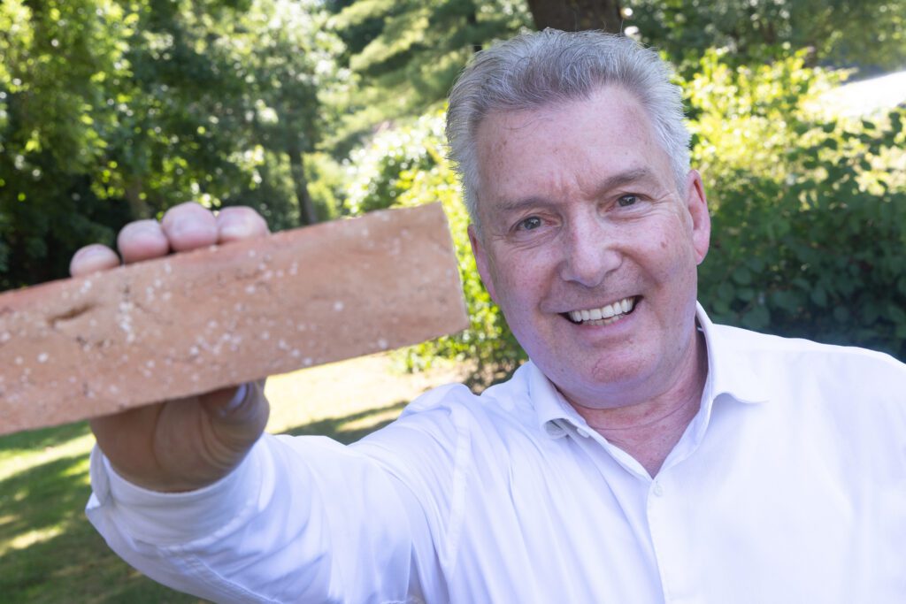 Jos van Oers, inkoopmanager bij Janssen de Jong Bouw met de kringloopsteen